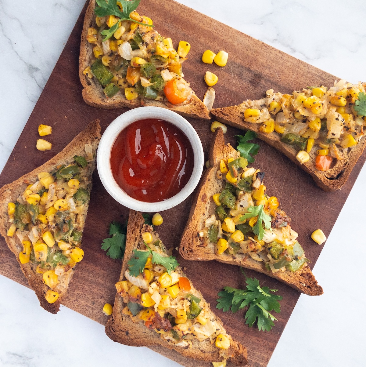 Toast loaded with vegetables on a wooden board