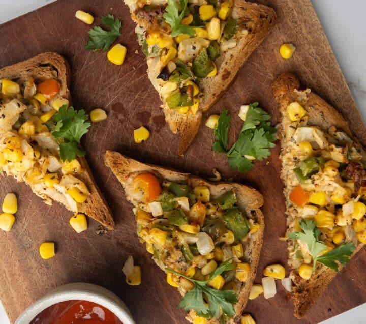 Toast loaded with vegetables on a wooden board