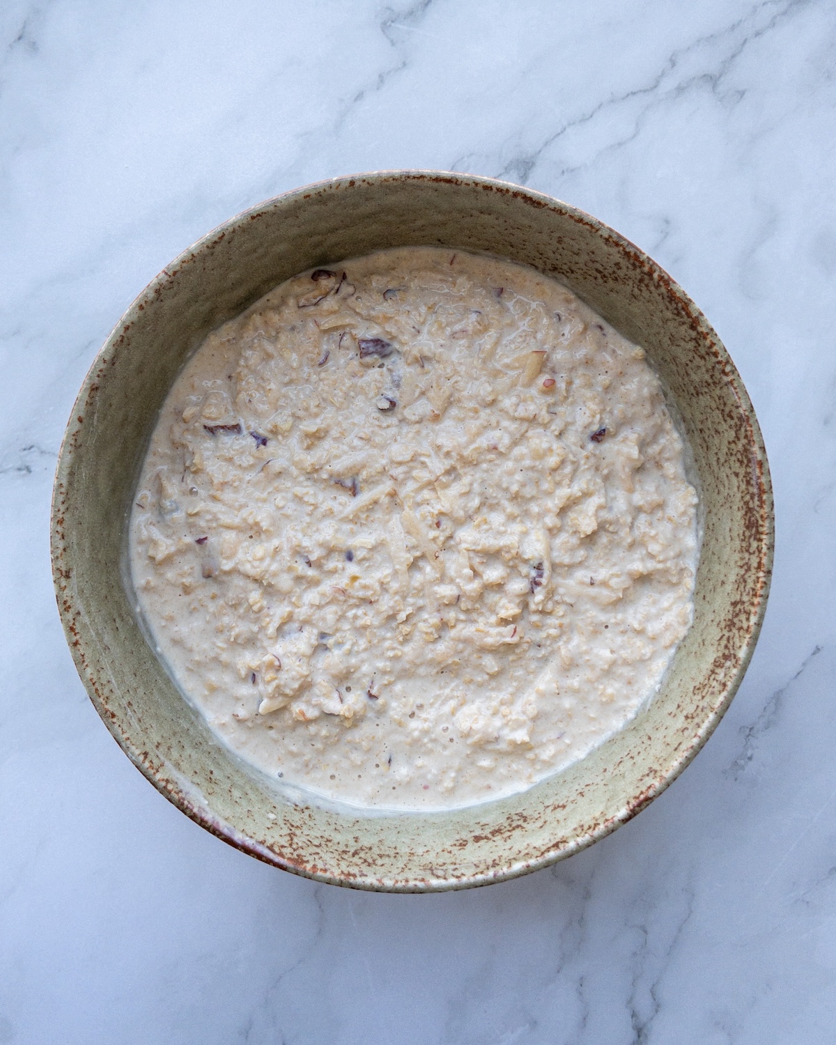 Bircher muesli ingredients mixed in a bowl