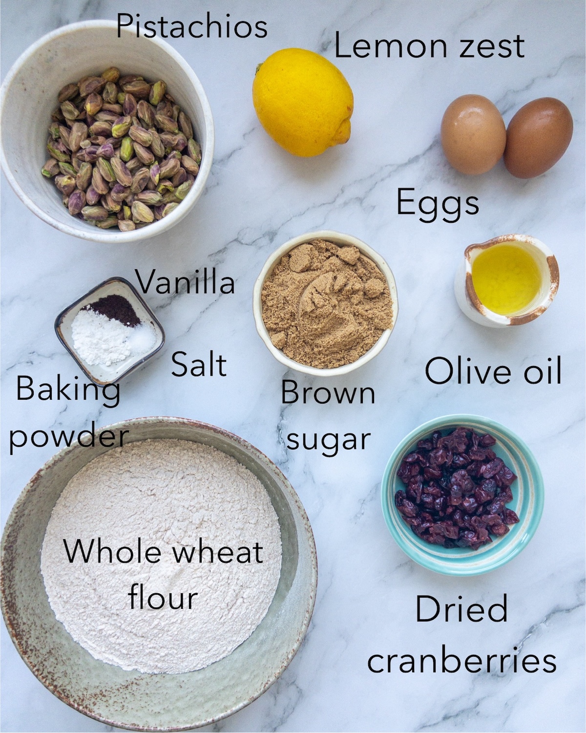 Ingredients for Pistachio and cranberry biscotti seen in bowls on a table