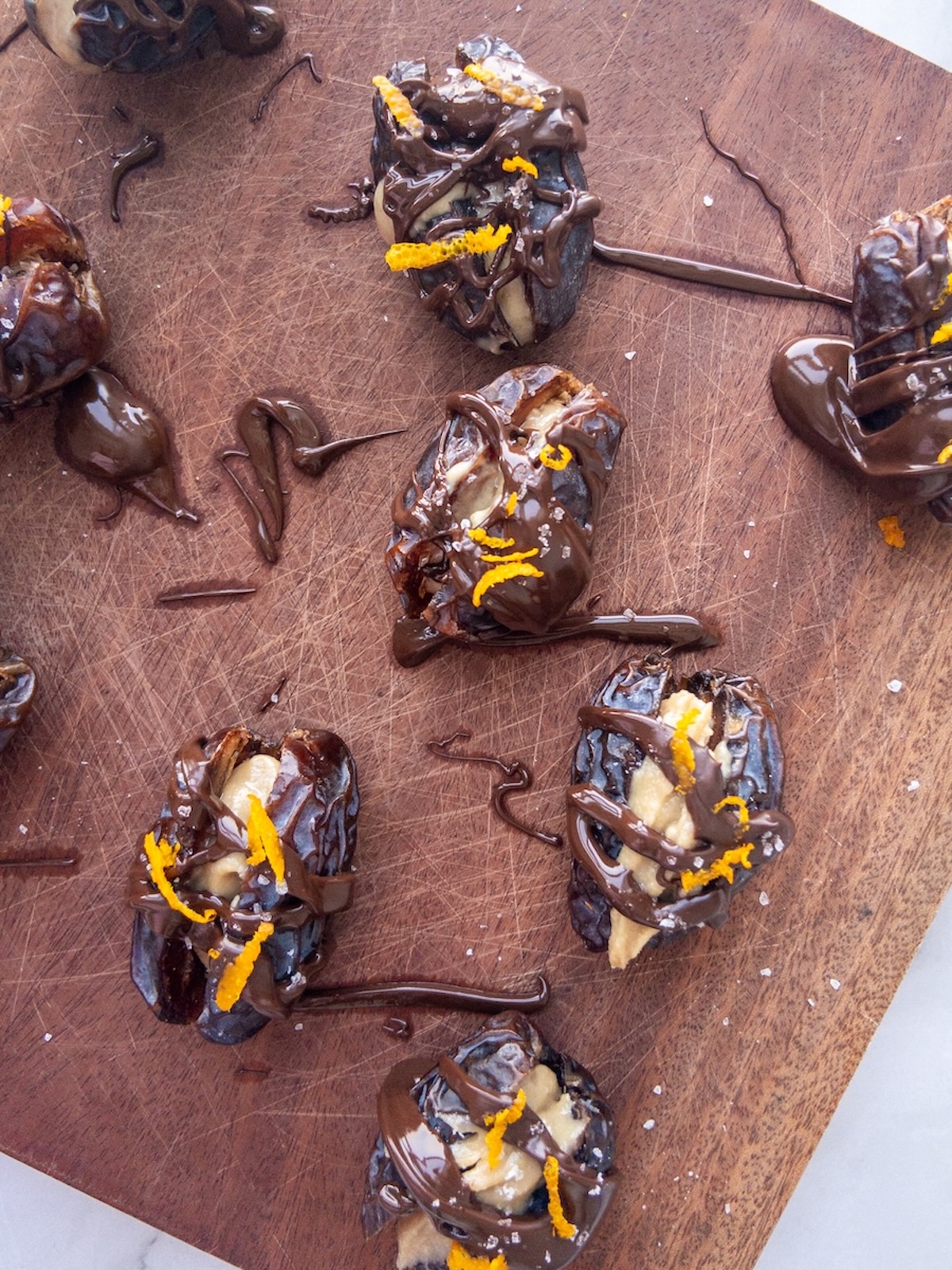 dates stuffed with tahini and topped with melted chocolate and orange zest
