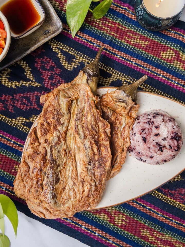 Tortang Talong, an eggplant omelette dish served with brown rice on a plate