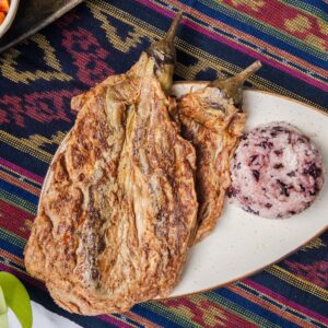 Tortang Talong, an eggplant omelette dish served with brown rice on a plate