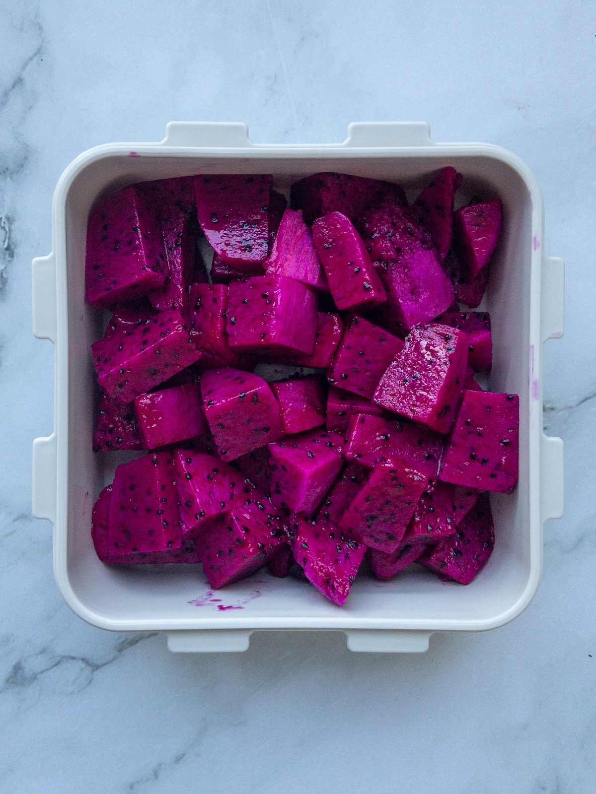 dragon fruit cubes inside a container to store.