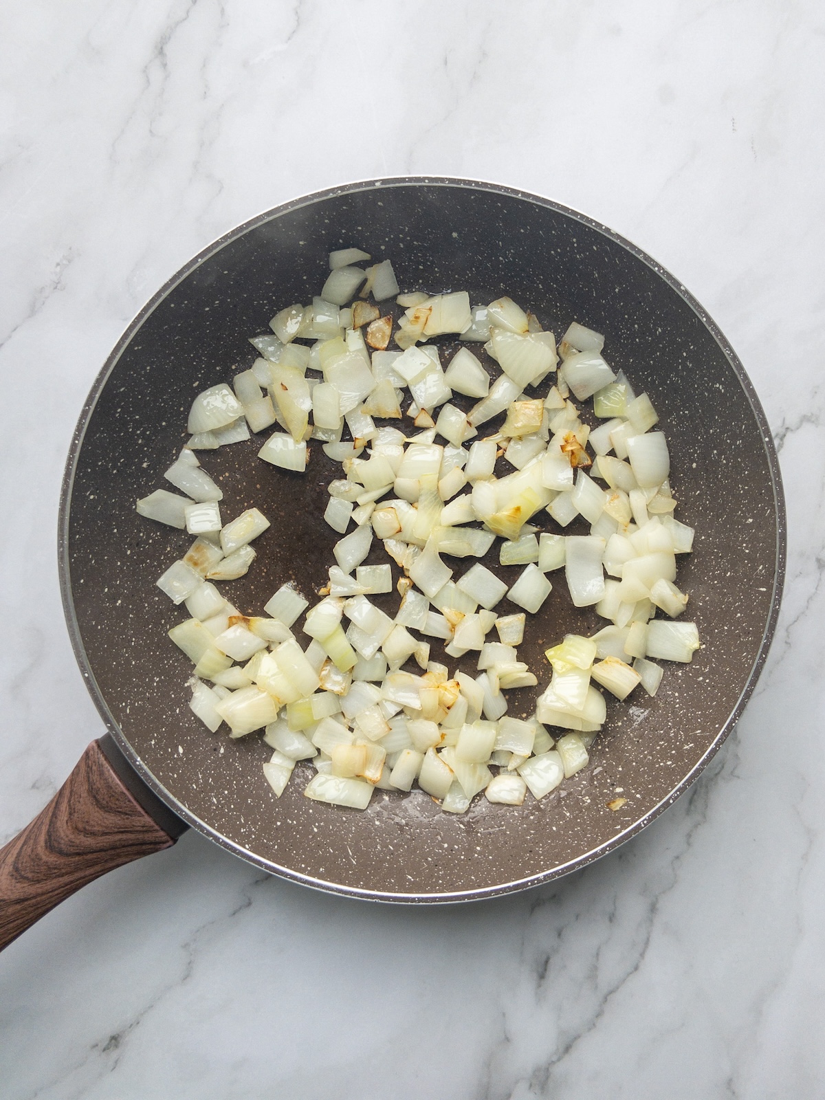 onions being cooked in a pan