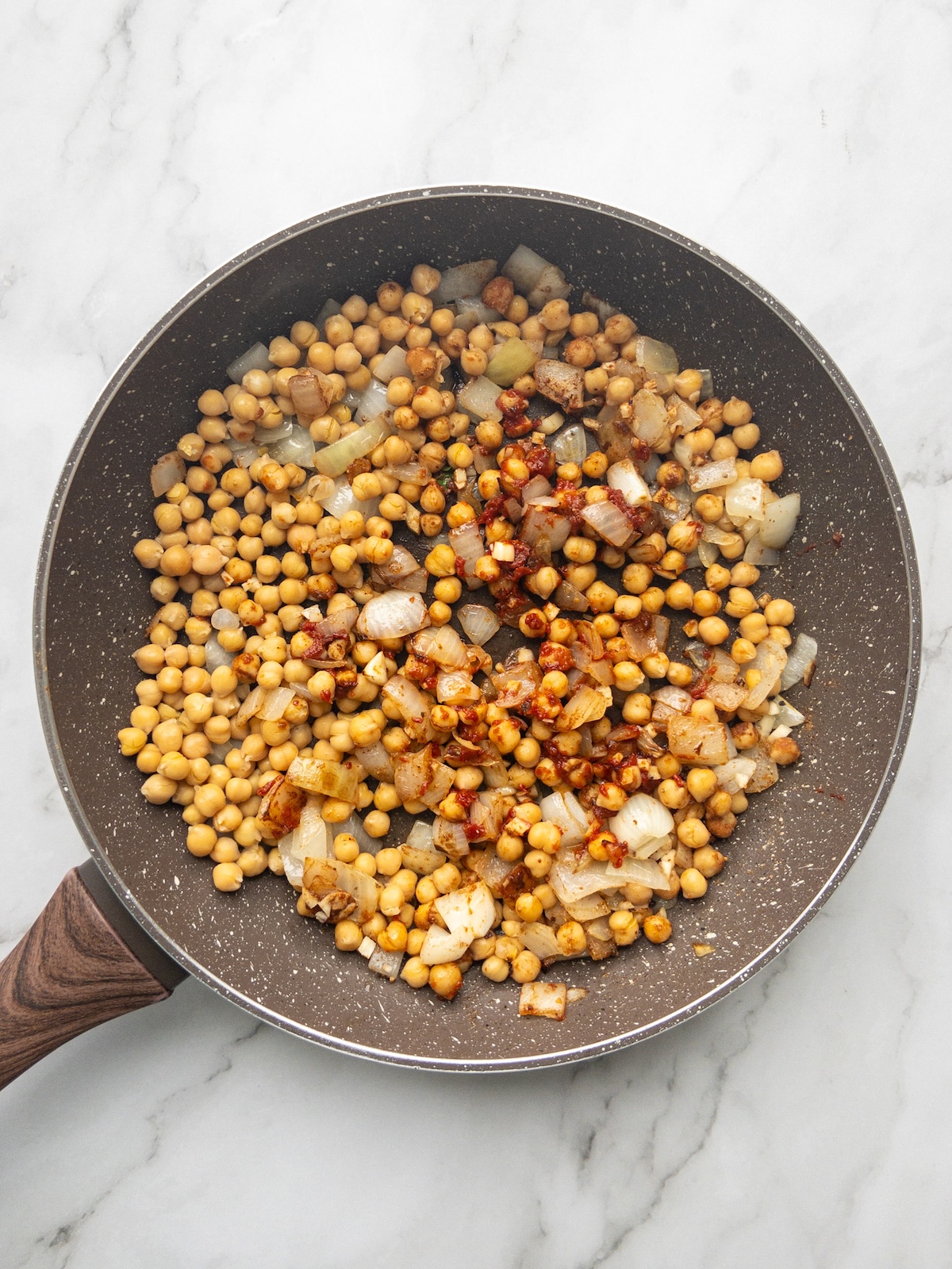 Maghmour being made in a pan. Chickpeas and spices cooking with onions