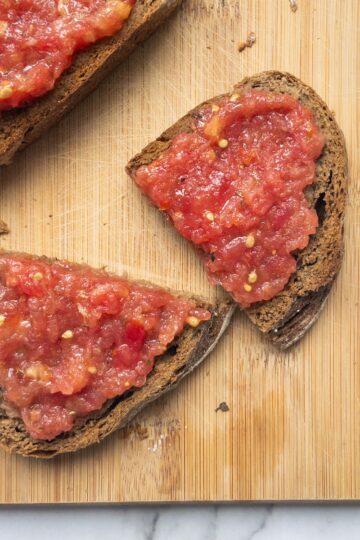 pa amb oli on a wooden board, one slice is cut in half
