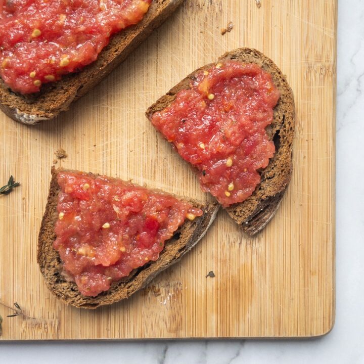 pa amb oli on a wooden board, one slice is cut in half