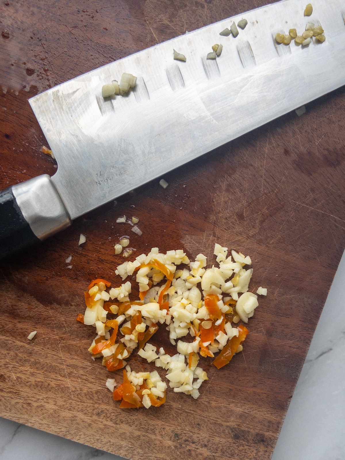 Minced garlic and chili on a wooden chopping board