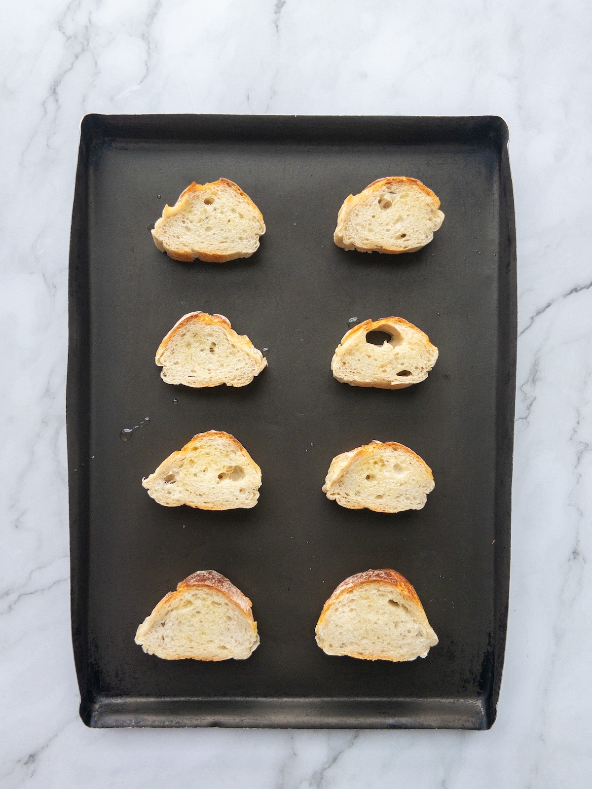 Slices of baguette placed on a baking tray