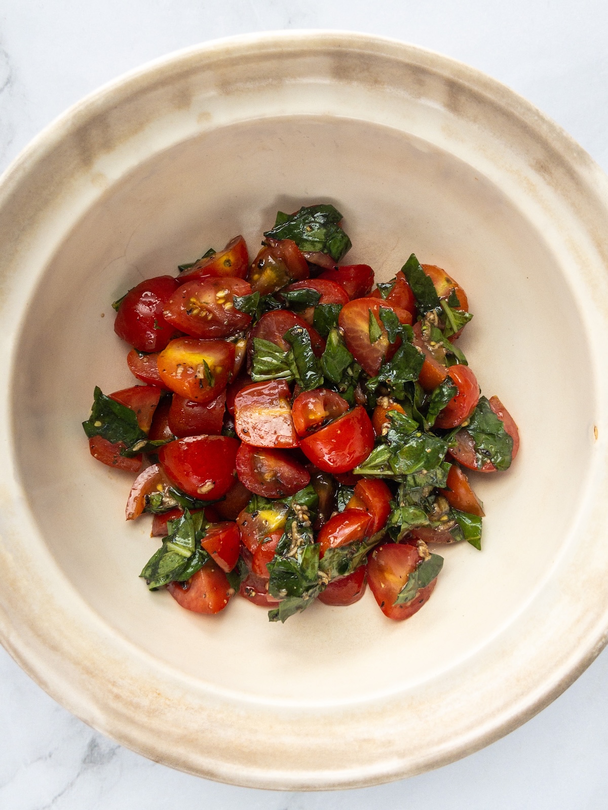 tomatoes and basil mixed in a bowl