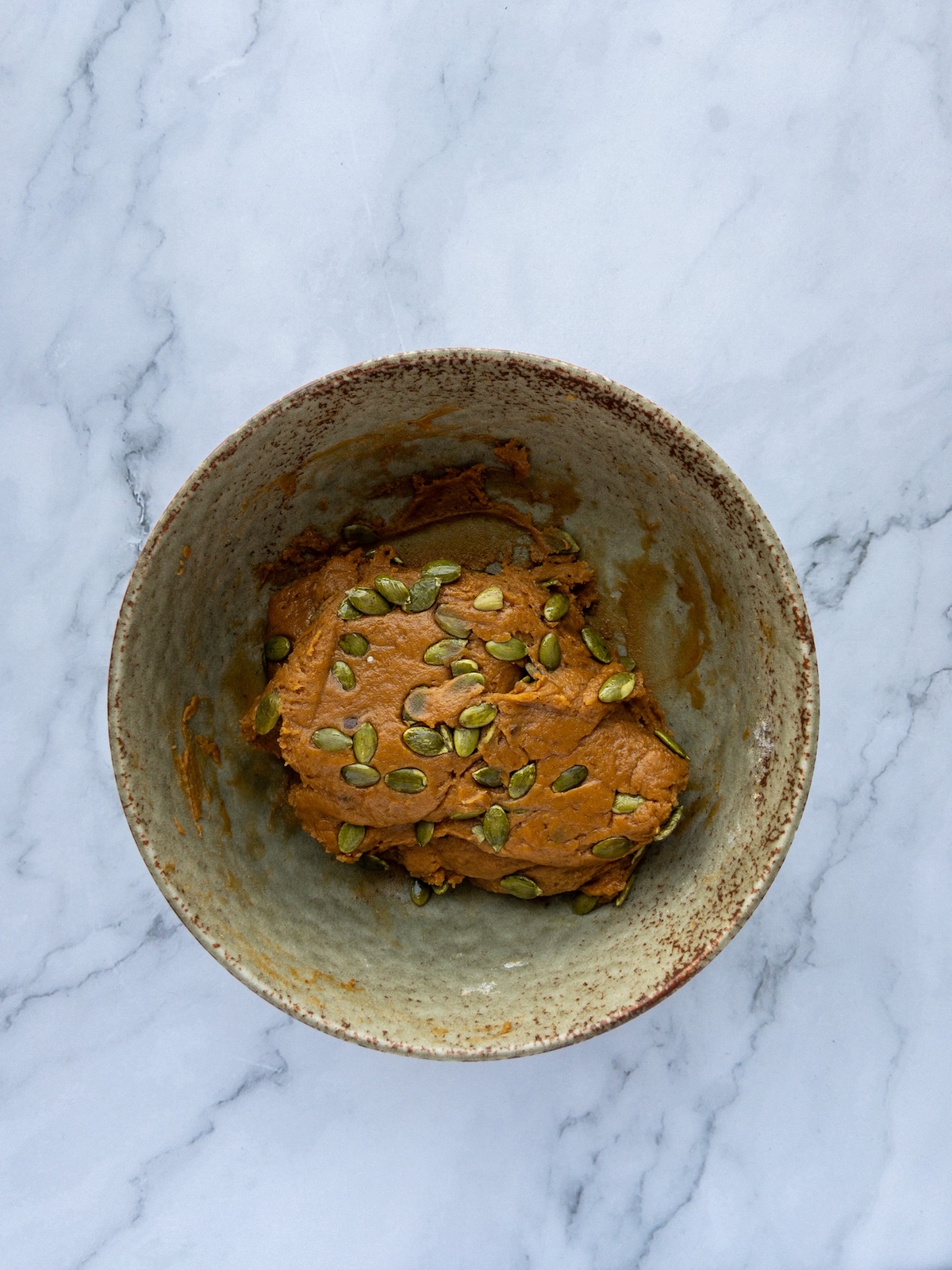 Pumpkin Biscotti dough in a bowl with pumpkin seeds